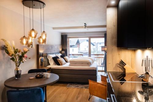 a room with a bed and a table and a kitchen at Residenz Illyrica Tirol in Westendorf