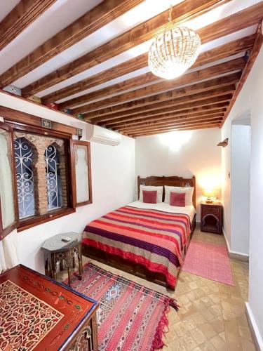 Schlafzimmer mit einem Bett und einem Kronleuchter in der Unterkunft Dar Sababa in Chefchaouen