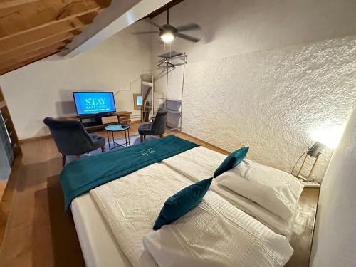 Schlafzimmer mit einem Bett, einem TV und einem Schreibtisch in der Unterkunft Chez Alain Prévu - Boutique Hotel by Stay Swiss in Pruntrut