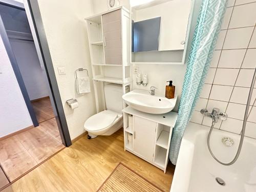 ein Bad mit einem Waschbecken, einem WC und einer Dusche in der Unterkunft Chez Alain Prévu - Boutique Hotel by Stay Swiss in Pruntrut