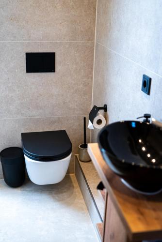 a bathroom with a black toilet and a sink at Angelinas Service Apartment 1 in Oberhausen