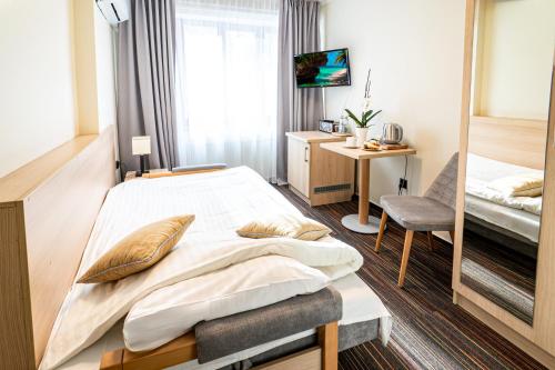 ein Hotelzimmer mit einem Bett und einem Schreibtisch in der Unterkunft Ośrodek Szkoleniowo-Wypoczynkowy "Leśnik" in Ustka