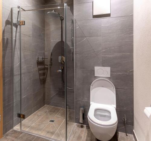 a bathroom with a toilet and a glass shower at Residenz Illyrica Tirol in Westendorf