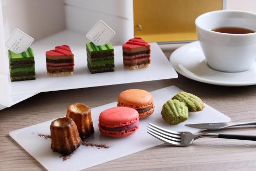 - une table avec des assiettes de pâtisseries et une tasse de café dans l'établissement The Royal Park Hotel Iconic Kyoto, à Kyoto