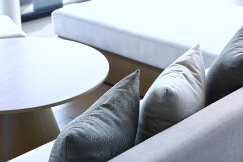 a couch with pillows and a table and a white table at The Royal Park Hotel Iconic Kyoto in Kyoto