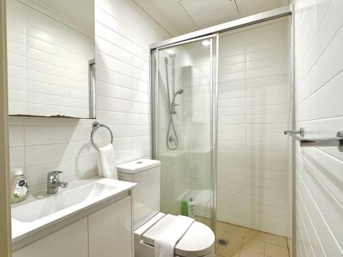 a bathroom with a toilet and a sink and a shower at Aircabin - Strathfield - Sydney - 2 Bedrooms Apt in Sydney