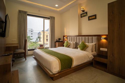 a bedroom with a large bed and a large window at RABBIT RATNAM -By Udaipur Hotels in Udaipur
