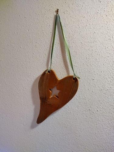 a wooden heart ornament hanging on a wall at FW Schnuckel in 300a Altem Bergbauernhaus 1110m in Plessnitz