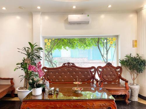 sala de estar con banco y ventana en FULL HOUSE Hotel, en Ðong Thon