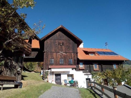 a large wooden barn with solar panels on it at FW Schnuckel in 300a Altem Bergbauernhaus 1110m in Plessnitz