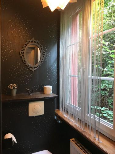 La salle de bains est pourvue d'un miroir, d'un lavabo et d'une fenêtre. dans l'établissement Logis Hôtel DOMAINE du MOULIN, à Saint-Avold