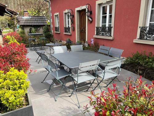 a table and chairs in front of a house at Logis Hôtel DOMAINE du MOULIN in Saint-Avold