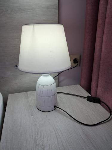 a white lamp sitting on a table with a lampost at city point in Kutaisi