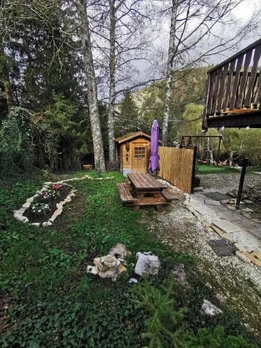 a small house with a picnic table and a purple umbrella at L'Orée, appartement cosy, 4 à 6 pers in Villard-de-Lans