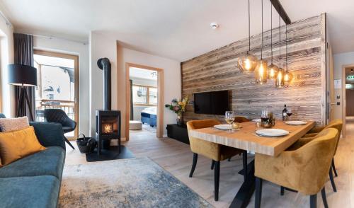 a living room with a dining table and a fireplace at Residenz Illyrica Tirol in Westendorf