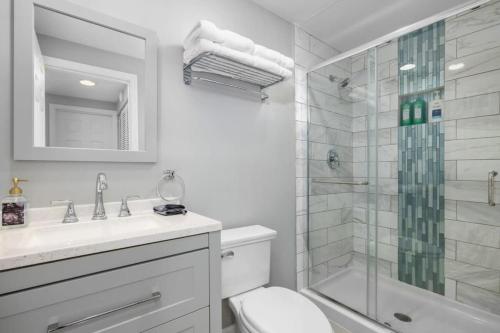 een witte badkamer met een douche en een toilet bij Cozy Studio in the Heart of Downtown Kimmswick 