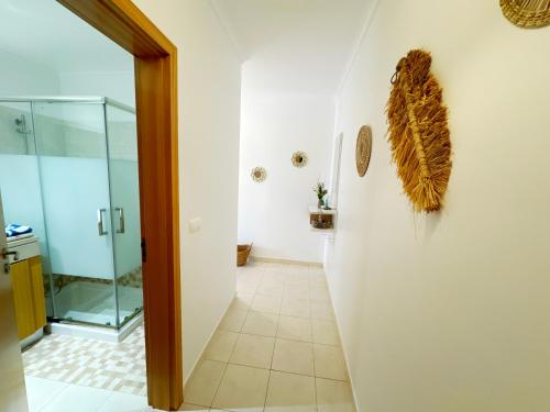 a bathroom with a shower and a glass door at Vista das Ondas Olhos de Agua Apartment in Olhos de Água