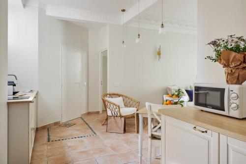 Il comprend une cuisine équipée d'un four micro-ondes, d'une table et de chaises. dans l'établissement Villa Berlioz, à Nice