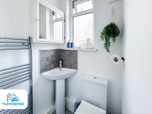 a white bathroom with a sink and a toilet at Modern House - Great Location - Free Parking in Headingley