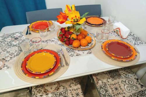 uma mesa com pratos e taças de fruta em Catania Easy Center Home em Catânia