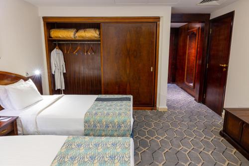a hotel room with a bed and a closet at Triumph Plaza Hotel in Cairo