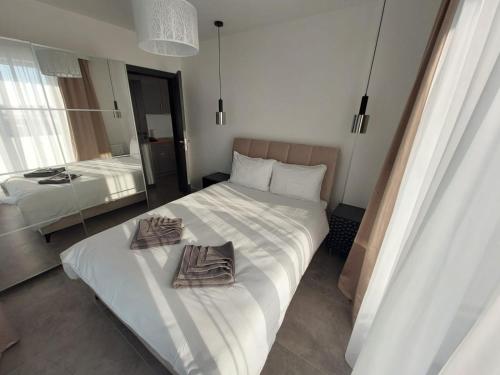 1 dormitorio con 1 cama con 2 toallas en Apartamenty Słoneczne Balkony en Sarbinowo
