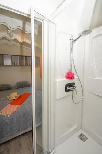 Cette chambre comprend un lit et une salle de bains pourvue d'une douche. dans l'établissement A La Rencontre Du Soleil - Camping, au Bourg-dʼOisans