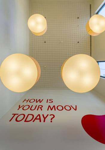 two lights hanging from the ceiling with a how is your moon today sign at Moov Hotel Porto Norte in Porto