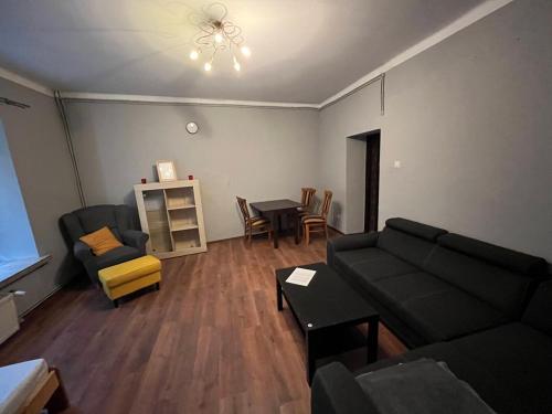 ein Wohnzimmer mit einem Sofa und einem Tisch in der Unterkunft ul. Mała 18/2 in Częstochowa