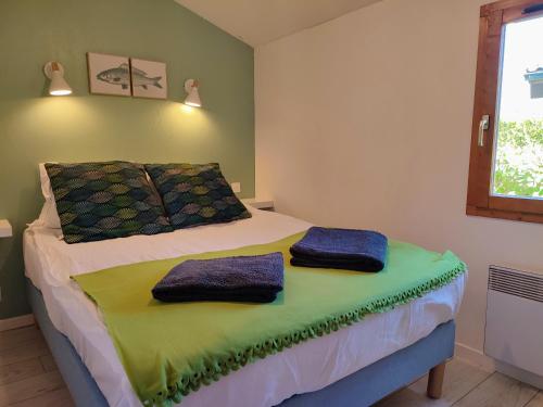 1 dormitorio con 1 cama con 2 toallas en Cabin No 7 Annecy Lake en Demi-Quartier