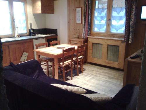 eine Küche und ein Esszimmer mit einem Tisch und Stühlen in der Unterkunft Le Foueustarle in La Giettaz