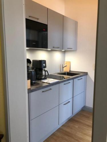 a kitchen with white cabinets and a sink at 7 Ferienwohnung - Ferien Mittendrin in Schwerin