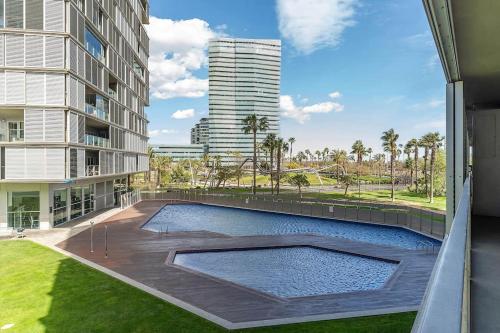 een zwembad voor een gebouw bij Canela Homes BARCELONA DIAGONAL MAR in Barcelona