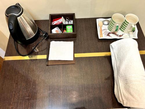 a room with a desk with a lamp and cups at Hotel Jyoti Stay Inn 10 Min to Ram Tample in Ayodhya