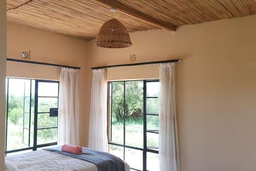 1 dormitorio con cama y ventana grande en Kichunguu FarmStay Cottage, en Oloitokitok 