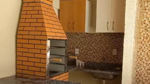 a kitchen with a brick wall next to a counter at AP532 Thermas Paradise Cobertura Duplex 2 quartos in Rio Quente