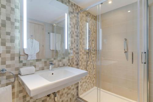uma casa de banho com um lavatório e um chuveiro em Pestana Tanger - City Center Hotel Suites & Apartments em Tânger