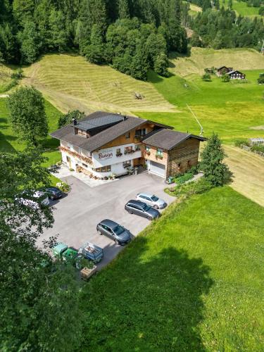 an aerial view of a building with cars parked in a parking lot at Pension Rudolph in Gaschurn