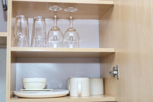 a cabinet filled with glasses and plates and bowls at Apartment in Nakuru in Nakuru