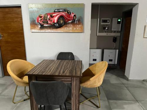 a dining room with a table and a red car painting at Mafikeng Boutique Lodge in Mahikeng