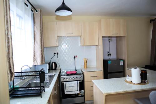 a small kitchen with a stove and a refrigerator at Apartment in Nakuru in Nakuru