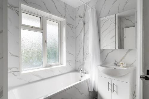 biała łazienka z umywalką i oknem w obiekcie Livestay 3 Bed House in Hendon Private Garden&Parking w mieście Colindale