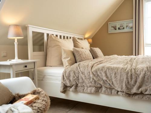 sypialnia z białym łóżkiem i krzesłem w obiekcie Haus Ostseezwilling 2 w Zingst