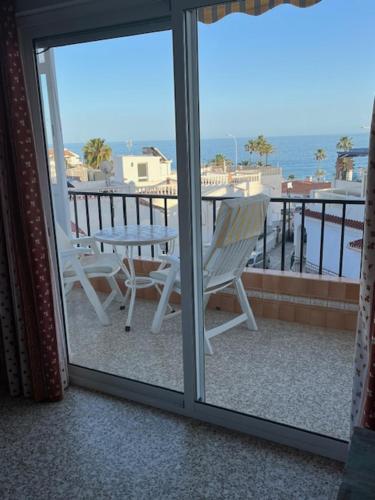 een balkon met een tafel en uitzicht op de oceaan bij ALBAIDA II 2B MENYBER in Nerja