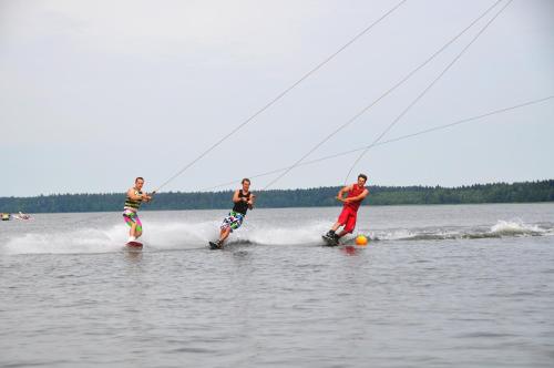 three people are water skiing on a lake at Villa Skomanda in Augustów