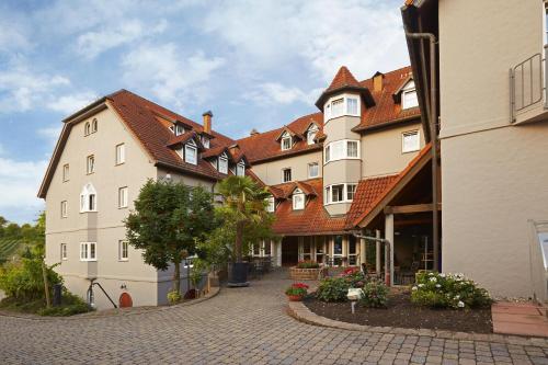 un grand bâtiment avec un toit rouge dans une rue dans l'établissement Consulat des Weins, à Sankt Martin