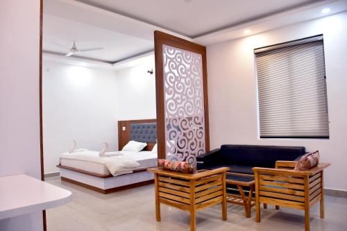 a bedroom with a bed and a mirror and a couch at Advent Hotel in Sūrajpur