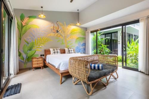 1 dormitorio con 1 cama y un mural tropical en Chakola Villa Ubud, en Ubud