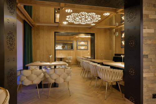 a restaurant with tables and chairs and a chandelier at Willa Zagroniówka in Istebna