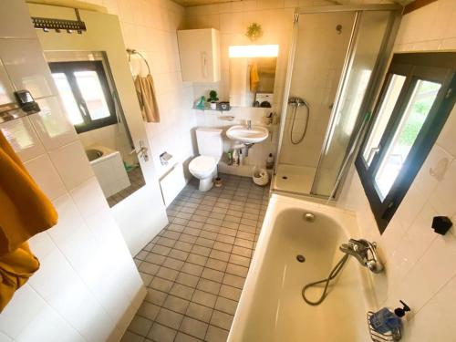 uma casa de banho com uma banheira, um WC e um lavatório. em Appartement Duplex entre Genève et Lausanne em Saint-Livres